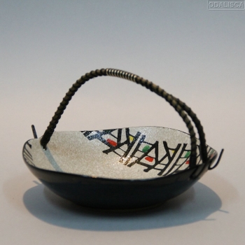 Realizado en cerámica esmaltada con un asa en caña o mimbre con metal plateado y plástico.